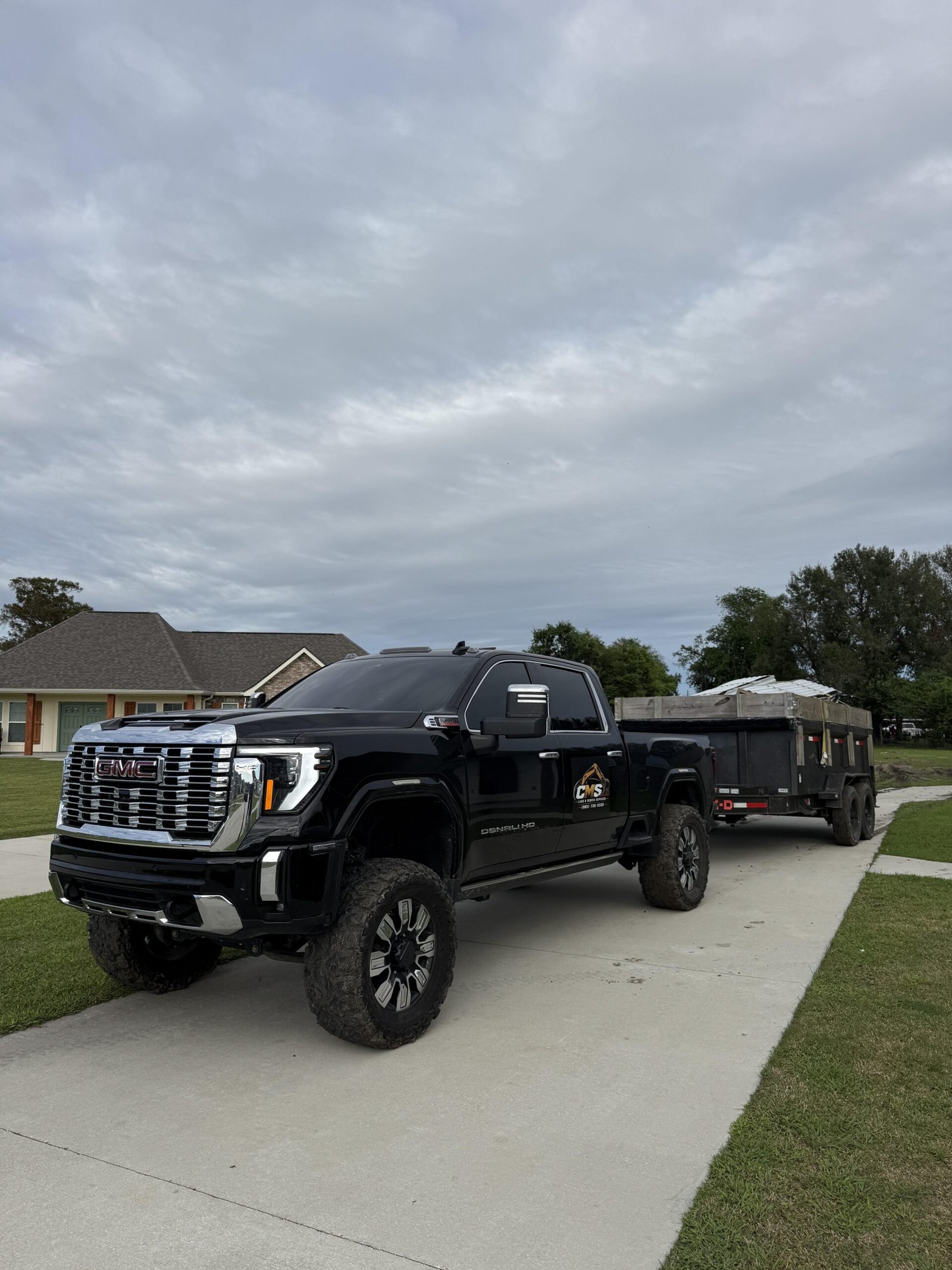 CMS Land & Debris GMC truck with loaded dump trailer